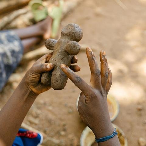 A mother makes a toy from clay during a childrenâ€™s toy making workshop in her community in Balaka district, Malawi.