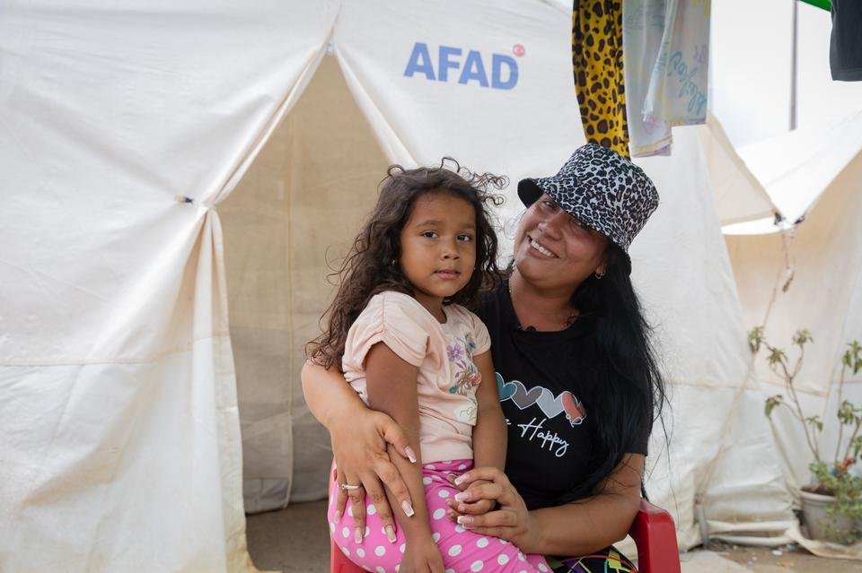 Marcela* (33) and her daughter Emma* (4) sit at their tent