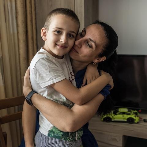 Marko*, eight, and his mum, Yana*, at their home in Bucharest, Romania