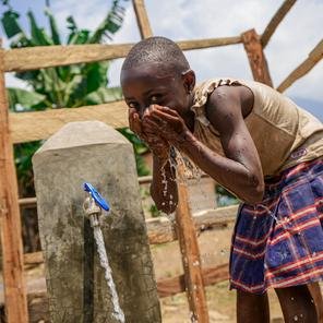Wivine*, 6 years old, happy about the availability of water in a spring built by SCI with funding from ECHO