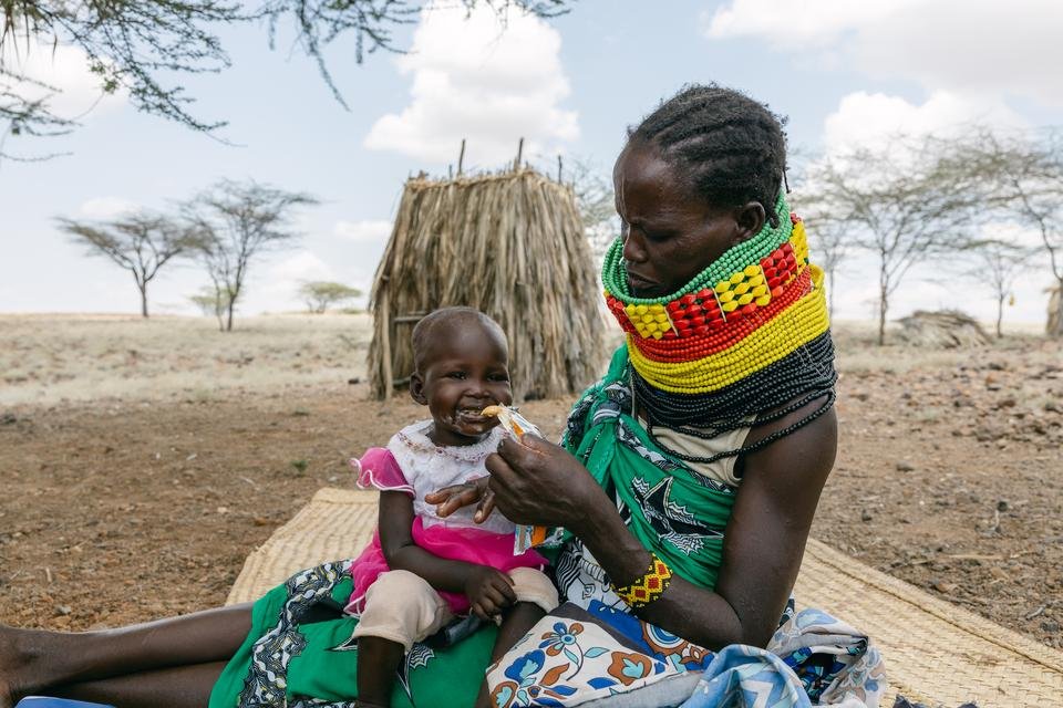 Ereng's mother feeds her fortified peanut paste