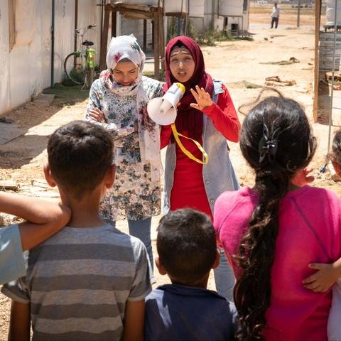 Hiba and Rama, sisters who rap about girls rights in Jordan, rap to children through a loudspeaker