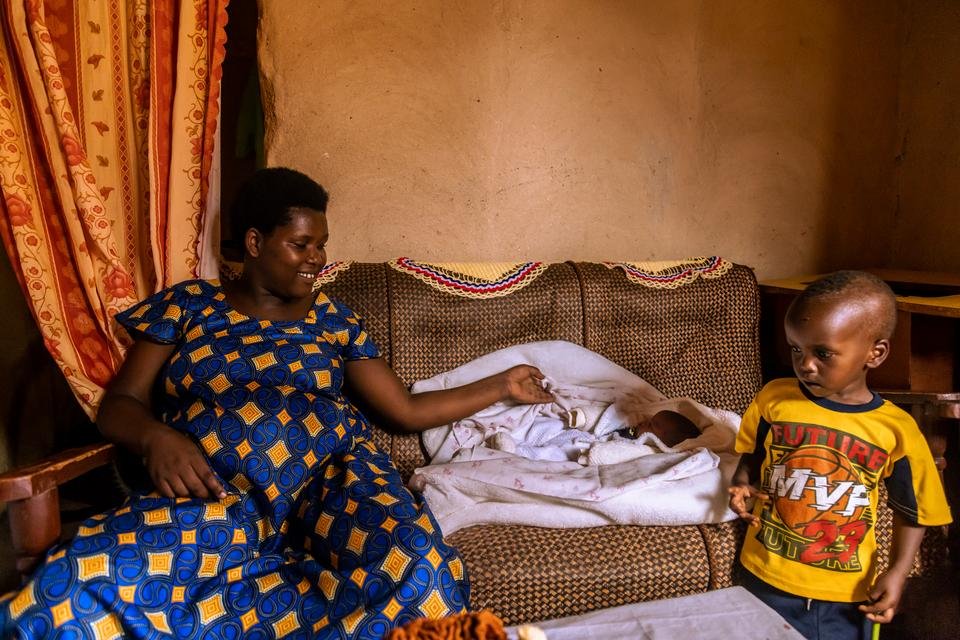 Beata*, 27, and her newborn Beni* inside their home in Mahama Refugee Camp, Rwanda.