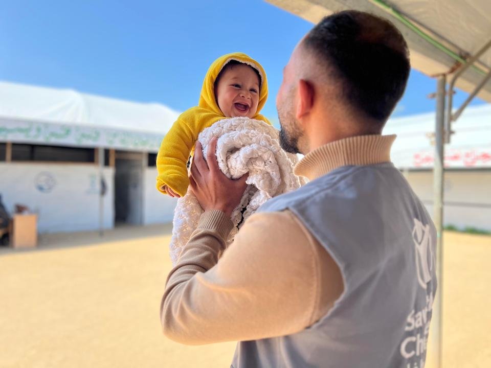 Sameer*, 6 Months, with Ali*, Shelter For Kids staff, during baby kit distribution