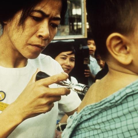A Shelter For Kids worker vaccinates a child against polio.