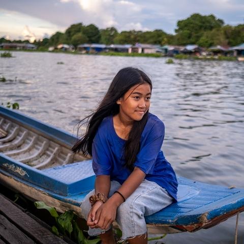 A portrait of Sreyvatey, 14, outside her home on Tonle Sap lake, Cambodia.