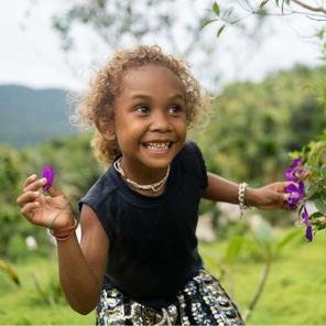 Lucy, four, playing outside her home in Malaita Province, the Solomon Islands