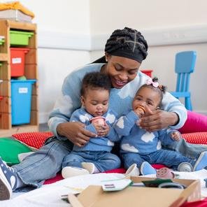 Joy* and her nine month old twins Evan* & Mitchell* play with the new Infant & Toddler Wonderpacks