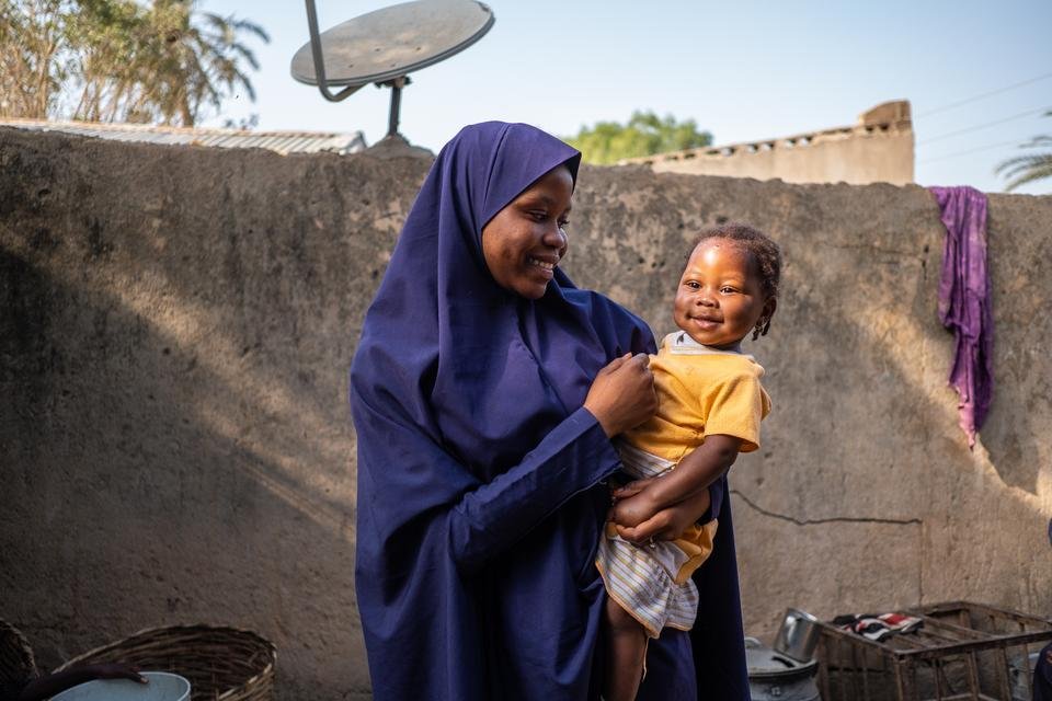 Amina, 14, with her younger sibling Saratou, who has recently recovered from pneumonia, outside their home in Jigawa State, Nigeria.
