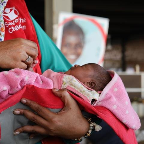 Shelter For Kids staff member holds newborn baby Sara* at mobile clinic, Sudan
