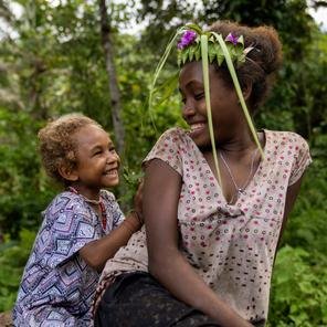 Lucy, four, playing with Joyce, 13, in a remote community in Malaita Province, the Solomon Islands.